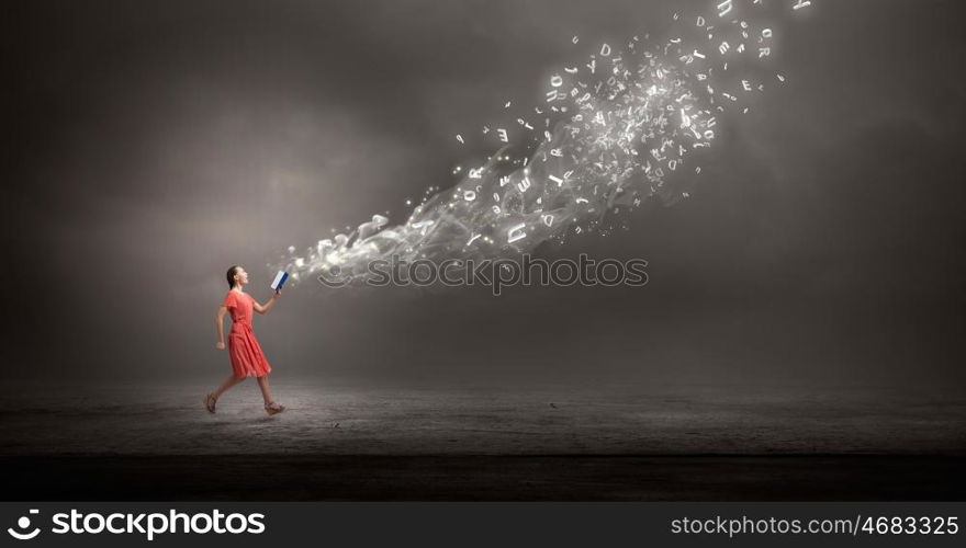 Attractive woman with book. Young woman in red dress running with book in hand