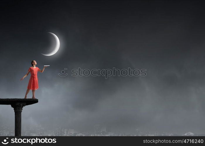 Attractive woman with book. Young woman in red dress running with book in hand