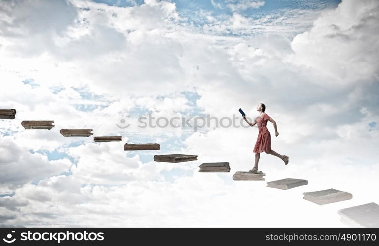 Attractive woman with book. Young woman in red dress running with book in hand