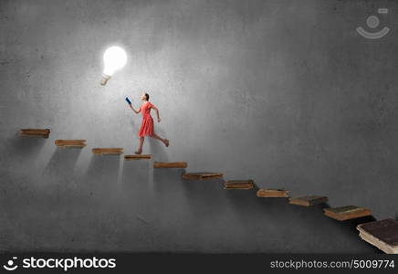 Attractive woman with book. Young woman in red dress running with book in hand