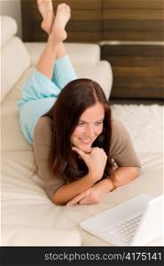 Attractive woman with laptop lying modern leather sofa living room