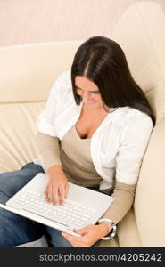 Attractive woman with laptop sitting on couch relax home