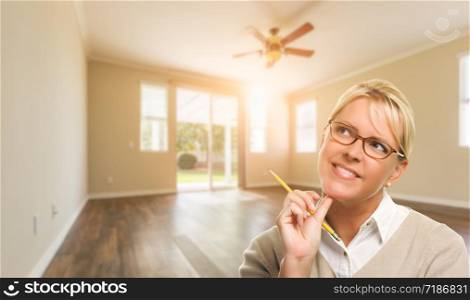Attractive Woman with Pencil In Empty Room of House.