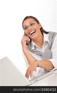 Attractive woman working with laptop holding phone