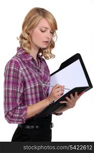 Attractive woman writing in a folder