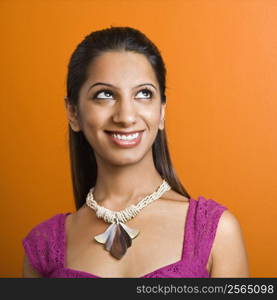 Attractive young adult Indian woman smiling at looking up.