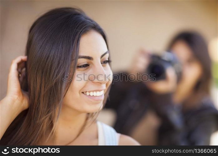 Attractive Young Adult Mixed Race Female Model Poses for a Photographer Outside.