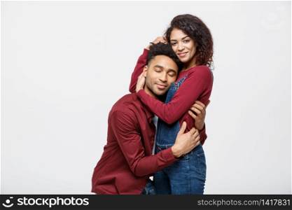 Attractive young african american lady ride back on her boyfriend and enjoy playing.. portrait of happy african american couple hug each other on white background.
