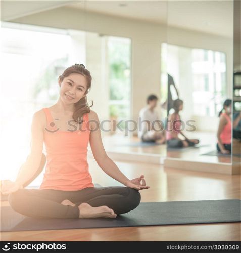 Attractive young Asian woman group exercising and sitting in yoga lotus position in yoga classes. asan