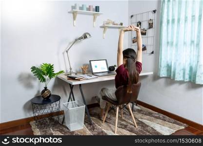 Attractive young beautiful asian woman working with laptop and document while sitting at the indoors living room office as a freelancer, e-coaching working, remotely or work from home concept