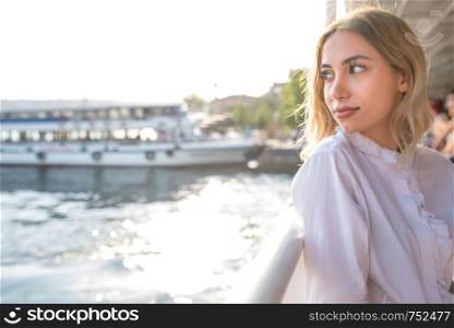 Attractive young beautiful girl enjoys moment while cruising with view of sea on background in Istanbul,Turkey.Traveler concept