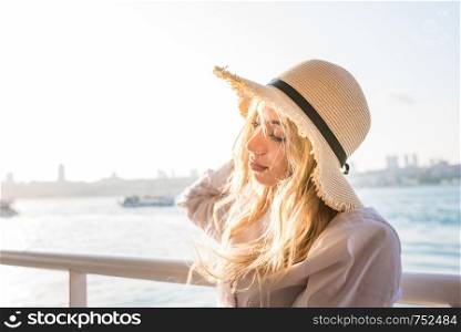 Attractive young beautiful girl enjoys moment while cruising with view of sea on background.Lifestyle concept