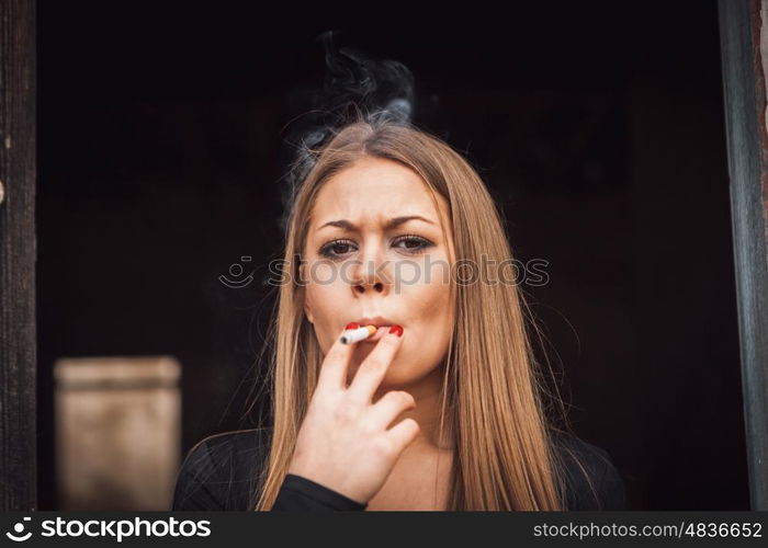 Attractive young blond girl smoking a cigar