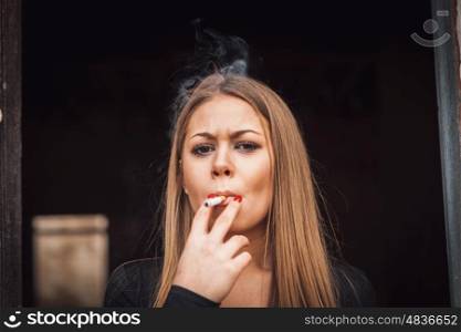 Attractive young blond girl smoking a cigar