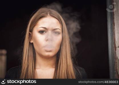 Attractive young blond girl smoking a cigar