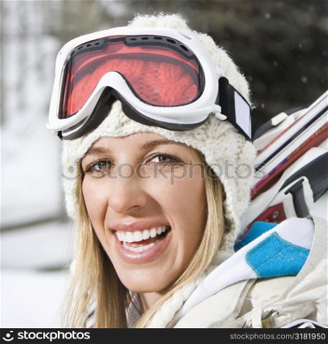 Attractive young blond woman in winter ski gear smiling.
