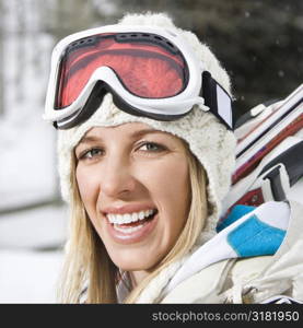Attractive young blond woman in winter ski gear smiling.