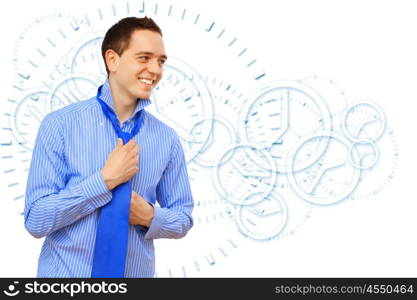 Attractive young business man binding his blue tie