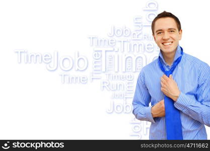 Attractive young business man binding his blue tie