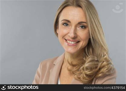 attractive young businesswoman looking camera against gray backdrop