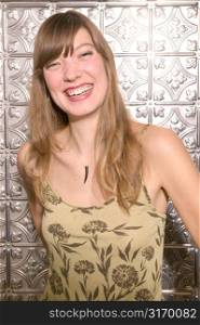 Attractive Young Caucasian Girl Laughing In Front Of A Shiny Metallic Wall