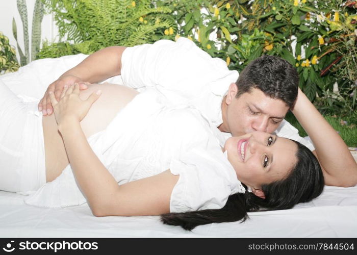 Attractive young caucasian pregnant couple in the park