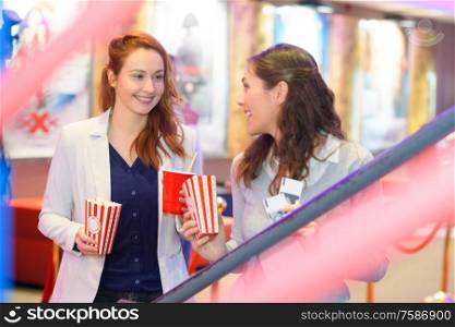 attractive young cheerful female friends enjoying the cinema