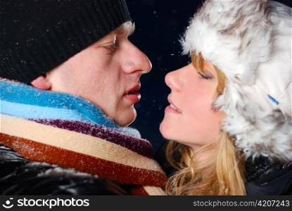 attractive young couple is kissing at winter evening