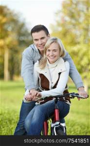 Attractive young couple on a bicycle in the park
