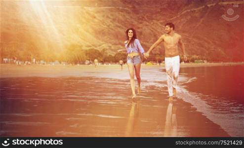Attractive, young couple walking along the seaside