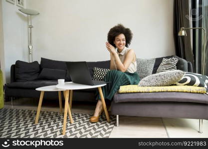 Attractive young curly hair woman working on laptop at home