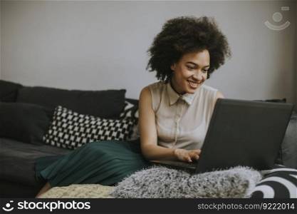 Attractive young curly hair woman working on laptop at home
