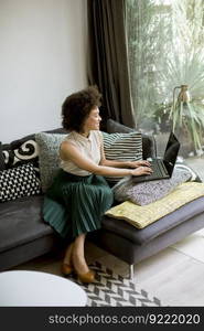 Attractive young curly hair woman working on laptop at home