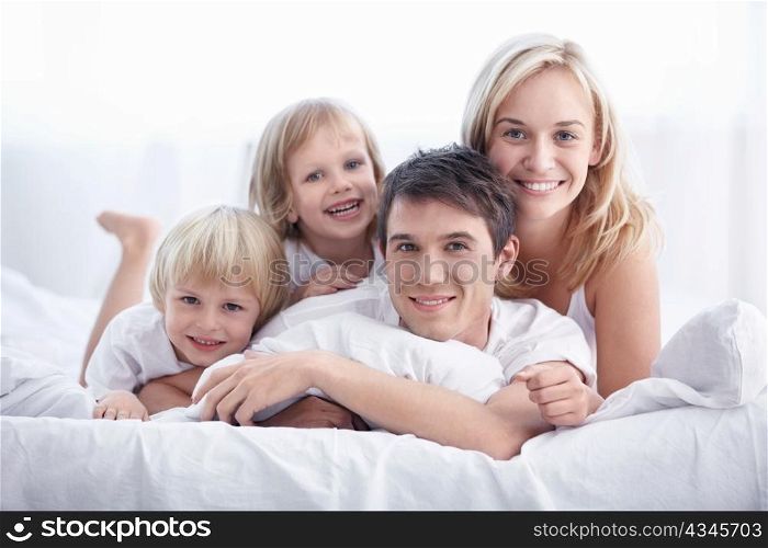 Attractive young family with children in the bedroom
