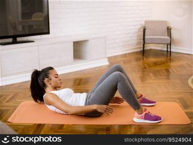 Attractive young female doing exercise in her living room