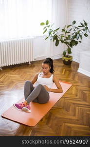 Attractive young female doing exercise in her living room