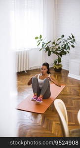 Attractive young female doing exercise in her living room