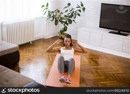 Attractive young female doing exercise in her living room