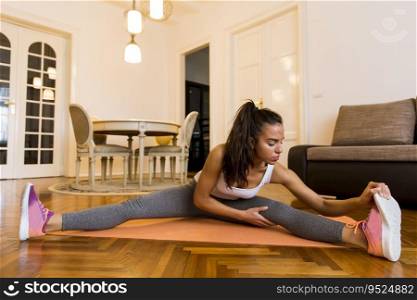 Attractive young female doing stretching exercise in her living room