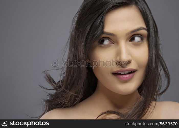 Attractive young female looking sideways over colored background