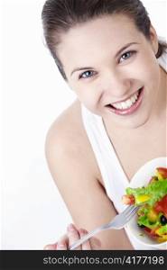 Attractive young girl eating salad on a white background
