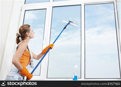 Attractive young girl washes windows