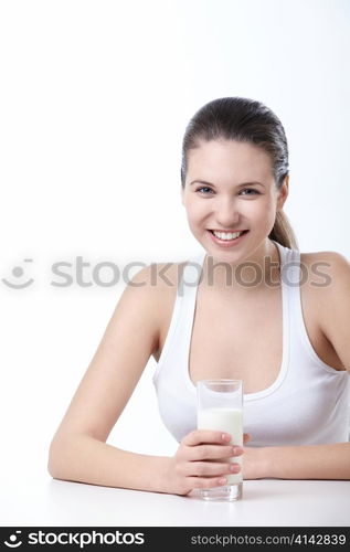 Attractive young girl with a glass of milk on a white background