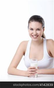 Attractive young girl with a glass of milk on a white background