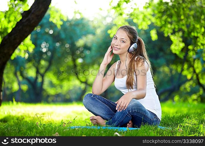 Attractive young girl with headphones in the park