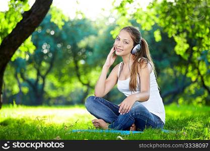 Attractive young girl with headphones in the park