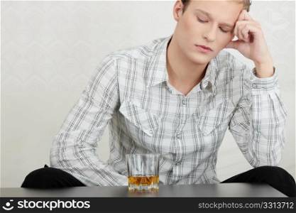 Attractive young guy drinking whiskey - depressed