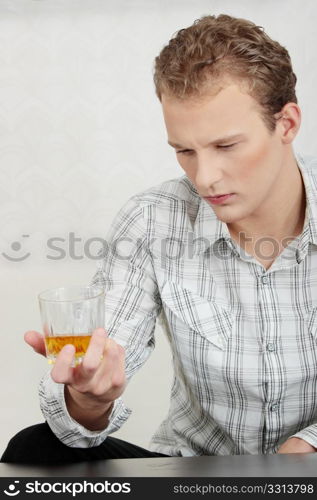 Attractive young guy drinking whiskey - depressed