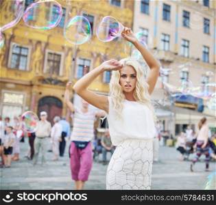Attractive young lady posing with soap bubbles