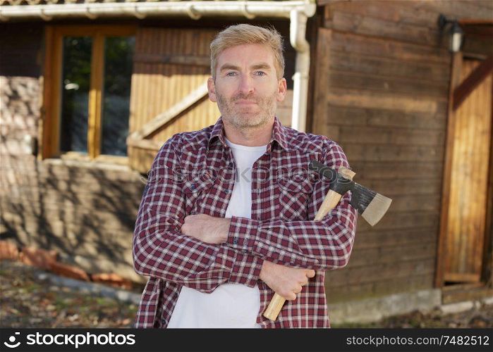 attractive young lumberjack posing with an axe